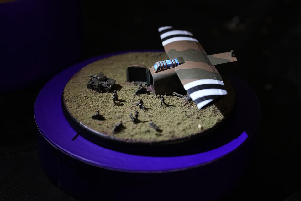 A model diorama showing a glider painted in D-Day stripes as it disgorges a tank and infantry, which was made as a 100th birthday gift for D-Day veteran Bill Gladden, shown at his surprise 100th birthday party in Haverhill, England Friday, Jan. 12, 2024. Gladden spoke to the AP on the eve of his 100th birthday, and is a veteran of the 6th Airborne Armoured Reconnaissance Regiment, part of the British 6th Airborne Division, he landed by glider on the afternoon of D-day, 6th June 1944 in Normandy. Gladden was born Jan. 13, 1924. (AP Photo/Alastair Grant)