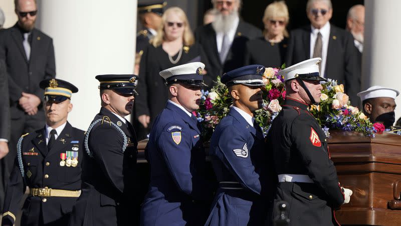 An Armed Forces team carries the casket of former first lady Rosalynn Carter after a tribute service at Glenn Memorial Church at Emory University on Tuesday, Nov. 28, 2023, in Atlanta. Amy Carter and her husband John Joseph “Jay” Kelly and James “Chip” Carter and his wife Becky watch.