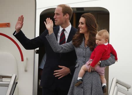 Britain's Catherine, the Duchess of Cambridge, waves with her husband Prince William, as she holds her son Prince George before they depart Canberra April 25, 2014. REUTERS/Phil Noble