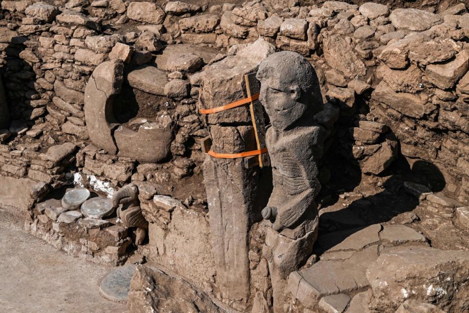 A photograph taken at the archaeological site of Karahantepe in Sanliurfa, southeastern Turkey on October 9, 2023, shows a newly found 2.3-meter high human statue (R), a stone man seated, clutching his sex with both hands, a vulture at his feet on the wall of a room. On this archaeological site, a stone statue, over 2.30 m high and seated on a bench adorned with a leopard, was discovered at the end of September in south-east Turkey, at the heart of a complex of some twenty sites that were home to thousands of humans during the Stone Age, twelve thousand years ago.<p>OZAN KOSE/Getty Images</p>