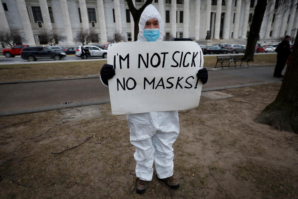 A protester holds a banner at a rally against mandates for the vaccines against the coronavirus disease (COVID-19) outside the New York State Capitol in Albany, New York, U.S., January 5, 2022. REUTERS/Mike Segar     TPX IMAGES OF THE DAY