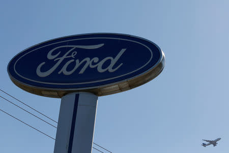 An airplane flies above a Ford logo in Colma, California, U.S., October 3, 2017. REUTERS/Stephen Lam