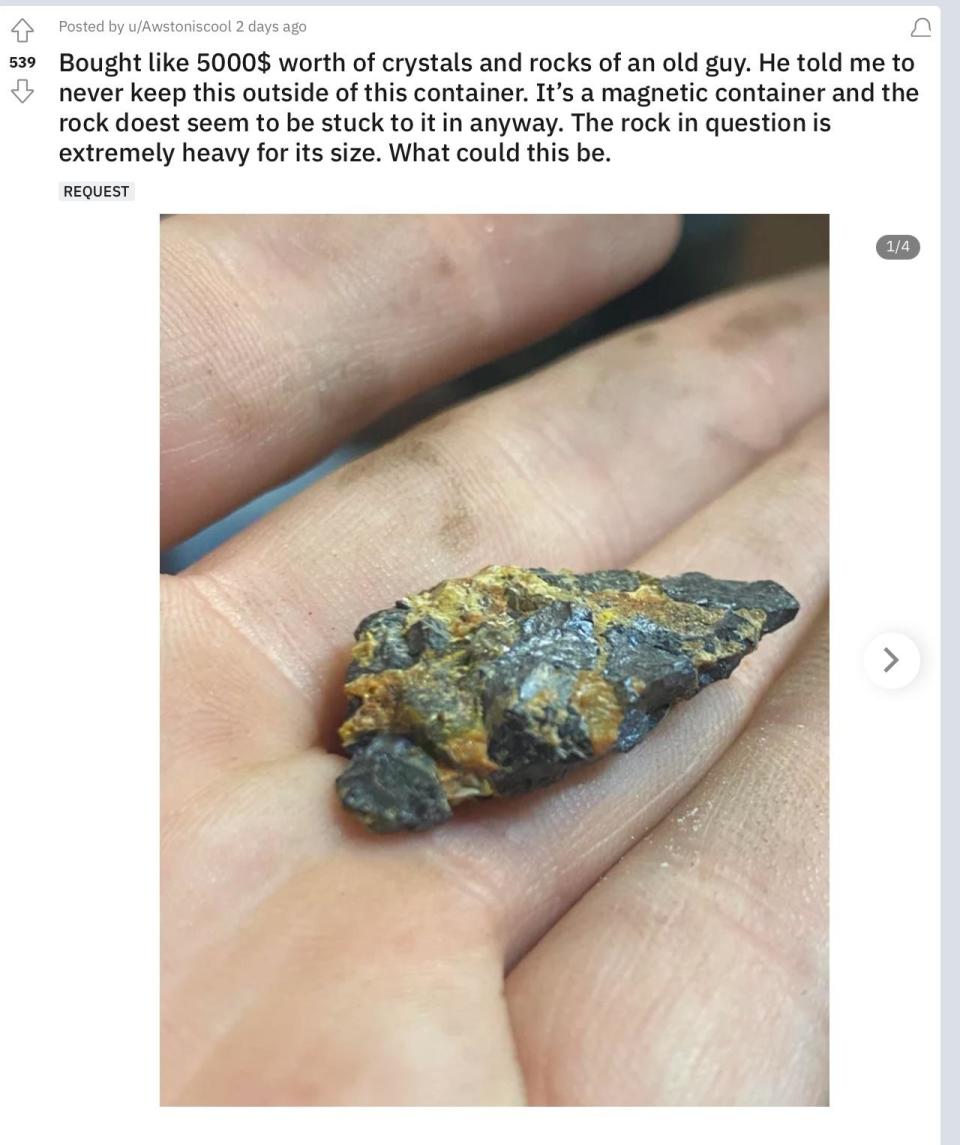 A hand holding a rock attached to a magnetic container. The owner claims the rock is extremely heavy and valuable, asking for insights about its origin