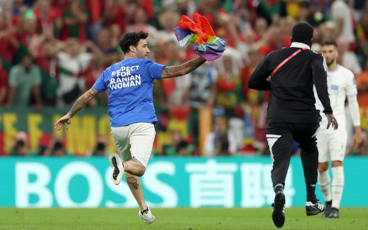 A pitch invader wearing a shirt reading "Respect for Iranian woman" holds a rainbow flag during the FIFA World Cup Qatar 2022 Group H match between Portugal and Uruguay at Lusail Stadium on November 28, 2022 in Lusail City, Qatar. - Lars Baron/Getty Images