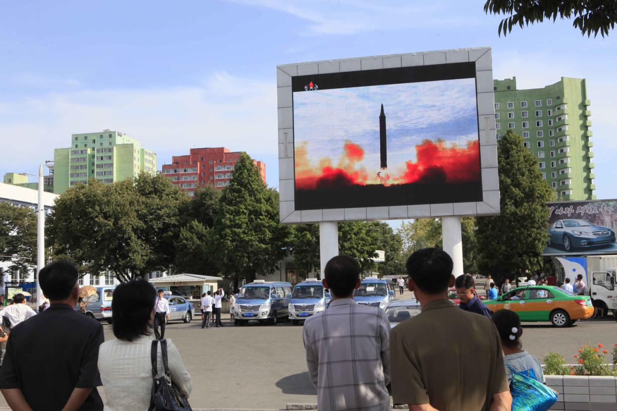 Growing threat: North Koreans in Pyongyang watch the latest missile launch on TV: AP