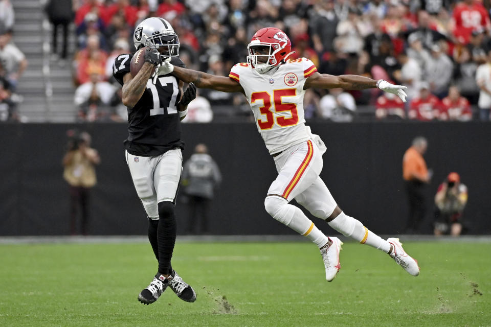 Las Vegas Raiders wide receiver Davante Adams (17) catches a pass as Kansas City Chiefs cornerback Jaylen Watson (35) defends during the first half of an NFL football game Saturday, Jan. 7, 2023, in Las Vegas. (AP Photo/David Becker)