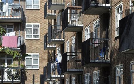 A man stands on a balcony in a residential high rise block of flats in Notting Hill in central London October 8, 2013. REUTERS/Toby Melville