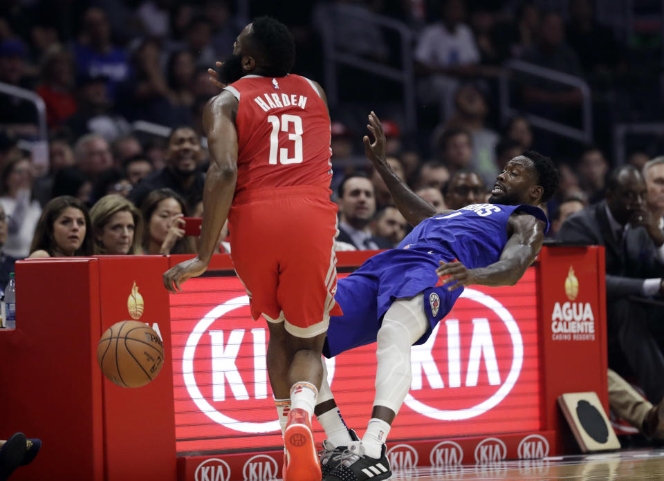 Houston Rockets' James Harden, left, collides with Los Angeles Clippers' Patrick Beverley during the first half of an NBA basketball game Sunday, Oct. 21, 2018, in Los Angeles. (AP Photo/Marcio Jose Sanchez)