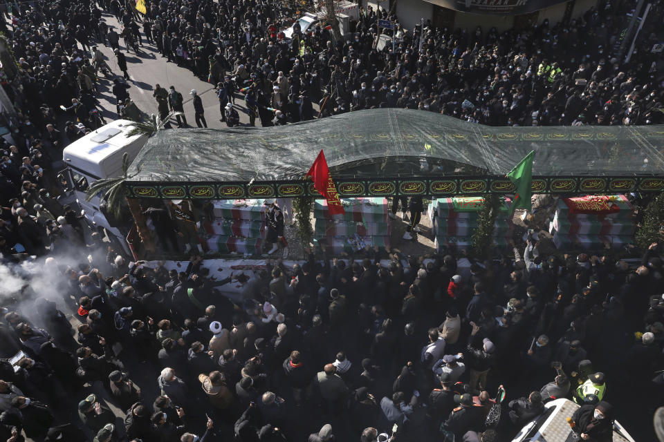 Mourners follow a truck carrying flag-draped caskets of unknown soldiers who were killed during the 1980-88 Iran-Iraq war, whose remains were recently recovered from former battlefields, during their funeral procession in Tehran, Iran, Thursday, Jan. 6, 2022. Thousands of mourners poured into the streets of Iranian cities on Thursday for the mass funeral of 250 victims of the war, a testament to the brutal conflict's widespread scale and enduring legacy 35 years later. (AP Photo/Vahid Salemi)