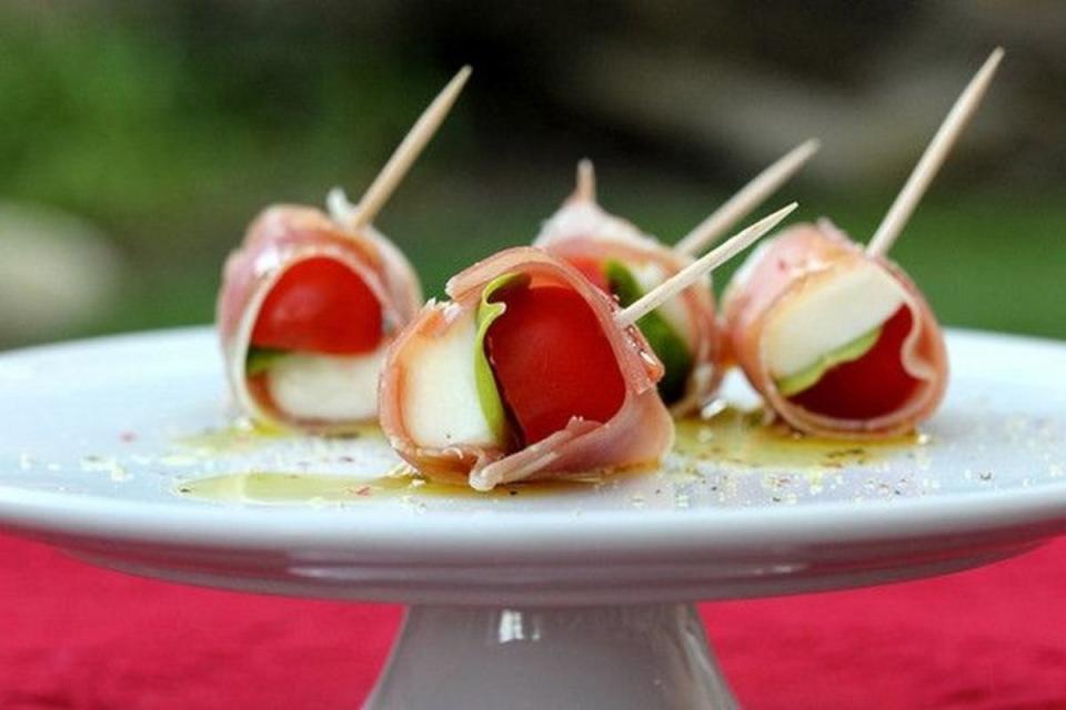 <p>Karen's Kitchen Stories</p><p>The perfect, portable appetizer to bring to a party—packed with flavor and easy to put together.</p><p><strong>Get the recipe: <a href="https://www.karenskitchenstories.com/2013/10/prosciutto-wrapped-cherry-tomatoes.html" rel="nofollow noopener" target="_blank" data-ylk="slk:Prosciutto-Wrapped Cherry Tomatoes, Mozzarella and Basil Bites;elm:context_link;itc:0;sec:content-canvas" class="link ">Prosciutto-Wrapped Cherry Tomatoes, Mozzarella and Basil Bites</a></strong></p>