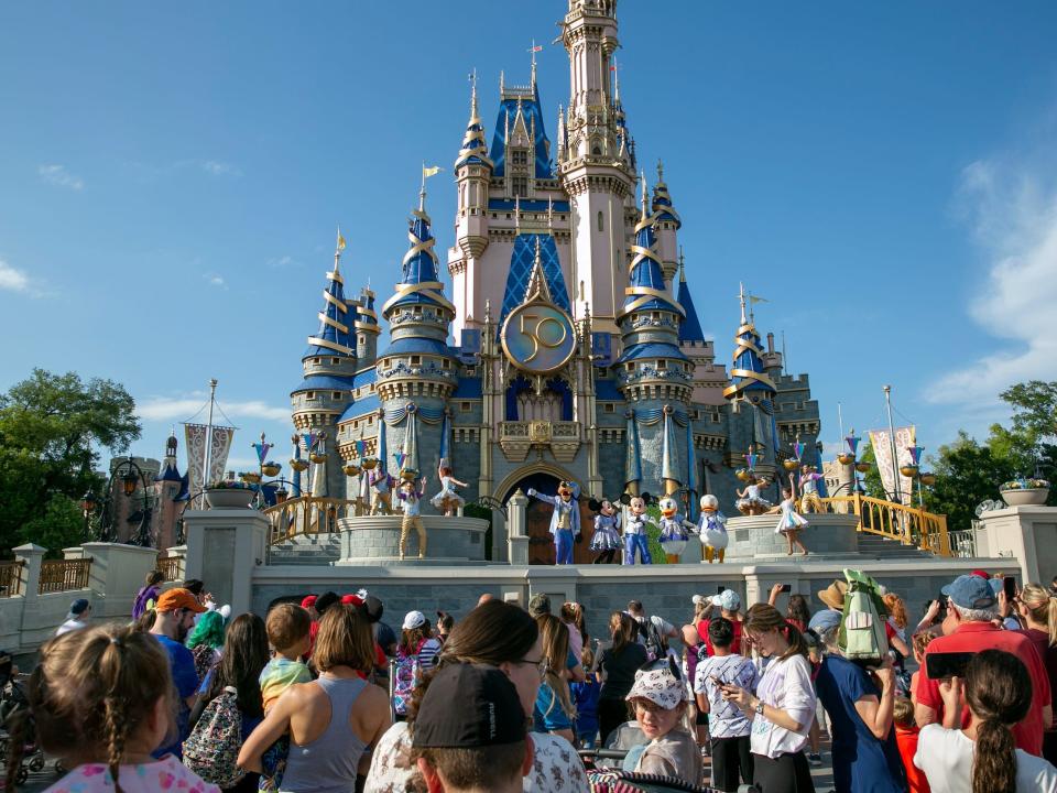 Performers dressed as Mickey Mouse, Minnie Mouse, Goofy, Donald Duck and Daisy Duck entertain visitors at Cinderella Castle at Walt Disney World Resort in Lake Buena Vista, Florida, on April 18, 2022.