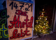 A sign in a shop window reads "the Ahrtal lives" in Bad Neuenahr in the Ahrtal valley, southern Germany, Monday, Dec.13, 2021. The region was hit by floodings exactly five months ago, causing the death of about 180 people.Amid the mud and debris still clogging the streets from last summer's devastating floods, residents of the Ahr Valley in western Germany are trying to spark some festive cheer with Christmas trees. (Photo/Michael Probst)