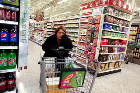 Puerto Rican Luz Brenda Lebron leans on a shopping cart after receiving a notification that she does not qualify for aid provided by the state to Puerto Ricans who were affected by Hurricane Maria, in Orlando, Florida, U.S., December 13, 2017. REUTERS/Alvin Baez