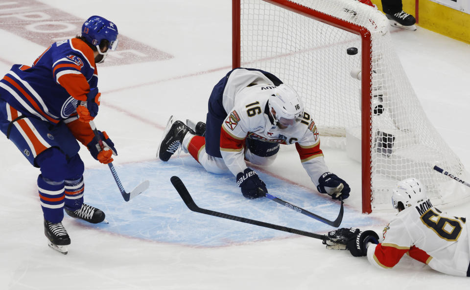 Edmonton Oilers' Mattias Janmark (13) scores as Florida Panthers' Aleksander Barkov (16) and Brandon Montour (62) defend during the first period of Game 4 of the NHL hockey Stanley Cup Final, Saturday, June 15, 2024, in Edmonton, Alberta. (Jeff McIntosh/The Canadian Press via AP)