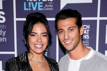 Danielle Olivera and Joe Bradley posing together in front of a step repeat at WWHL in New York City.