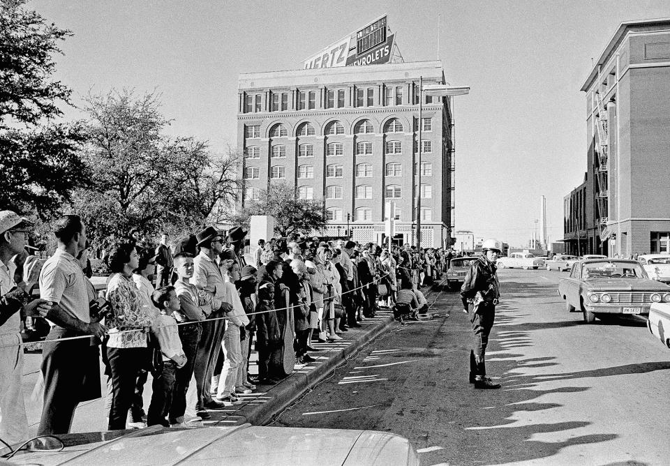 <p>The street across from the Dallas criminal courts building on Nov. 23, 1963, which houses the county jail, is lined with people hoping for a glimpse of Lee Harvey Oswald, accused of assassinating President John Kennedy, should he be moved from the city jail. The building is near the one, background, from which the fatal shots were fired. (Photo: AP) </p>