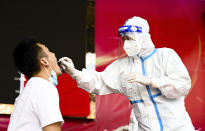 FILE - In this July 5, 2021, file photo released by Xinhua News Agency, a medical worker collects a swab sample for nucleic acid test in Ruili City of southwest China's Yunnan Province. Everyone in a county in China's southwest near Myanmar will be tested for the coronavirus following a spike in infections, the government announced Saturday, July 24, 2021. (Wang Guansen/Xinhua via AP, File)