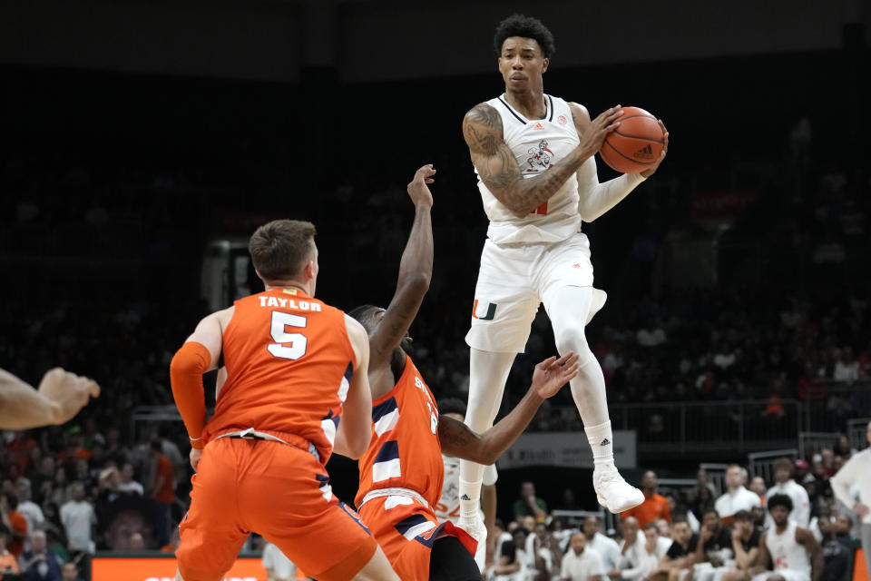 Miami forward Anthony Walker, right, looks to pass during the first half of an NCAA college basketball game against Syracuse, Monday, Jan. 16, 2023, in Coral Gables, Fla. (AP Photo/Lynne Sladky)