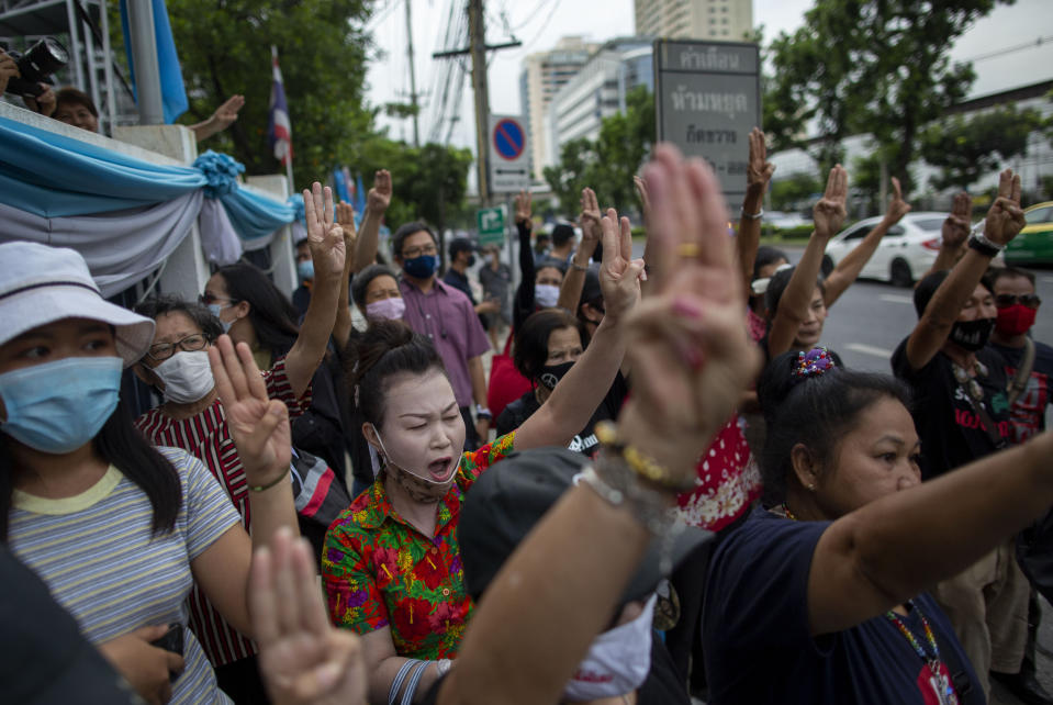 Pro-democracy activists raise a three-fingers, symbol of resistance salute outside the criminal courthouse in Bangkok, Thailand, Thursday, Aug. 20, 2020. Thai police arrested nine pro-democracy activists, including two rappers, in a crackdown on growing protests that have emerged as the most serious threat to the government led by a former army general they accuse of incompetence and corruption. Thai criminal court released all nine of them on bail. (AP Photo/Gemunu Amarasinghe)