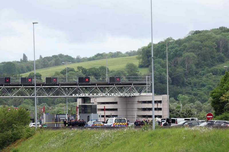 Police officers work at the scene of a ramming attack that took place late this morning at a toll booth in Incarville in the Eure region of northern France. Police officers were killed and others injured in an attack on a prisoner transport in the north of France. Alain Jocard/AFP/dpa