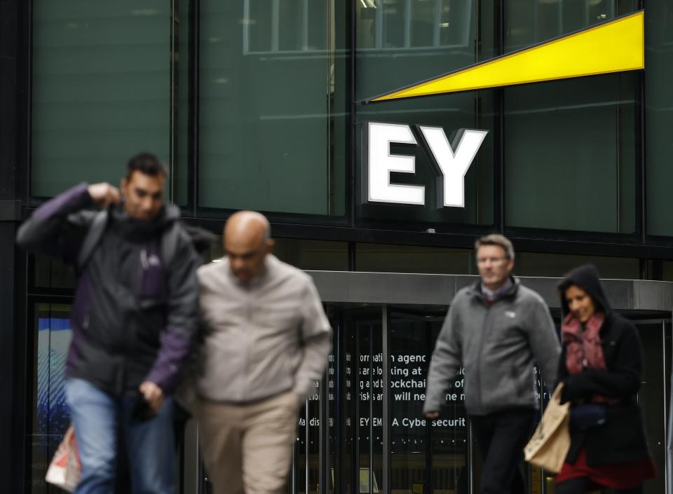 Pedestrians walk past the offices of accounting and auditing firm EY, formerly Ernst & Young, in London on November 20, 2020. - Britain's audit sector, dominated by the so-called Big Four accountancy giants, is shortly expected to discover how it must reinvent itself amid a series of probes into alleged corruption, including one linked to the collapse of German electronic payments group Wirecard. The Department for Business, Energy and Industrial Strategy (BEIS) is reportedly set to publish reform proposals before Christmas amid fraudulent probes into EY-linked activities at Denmark's Danske Bank and Wirecard. EY has been accused of failing to warn about suspicious transactions at Danish bank Danske Bank worth billions of euros. (Photo by TOLGA AKMEN / AFP) (Photo by TOLGA AKMEN/AFP via Getty Images)