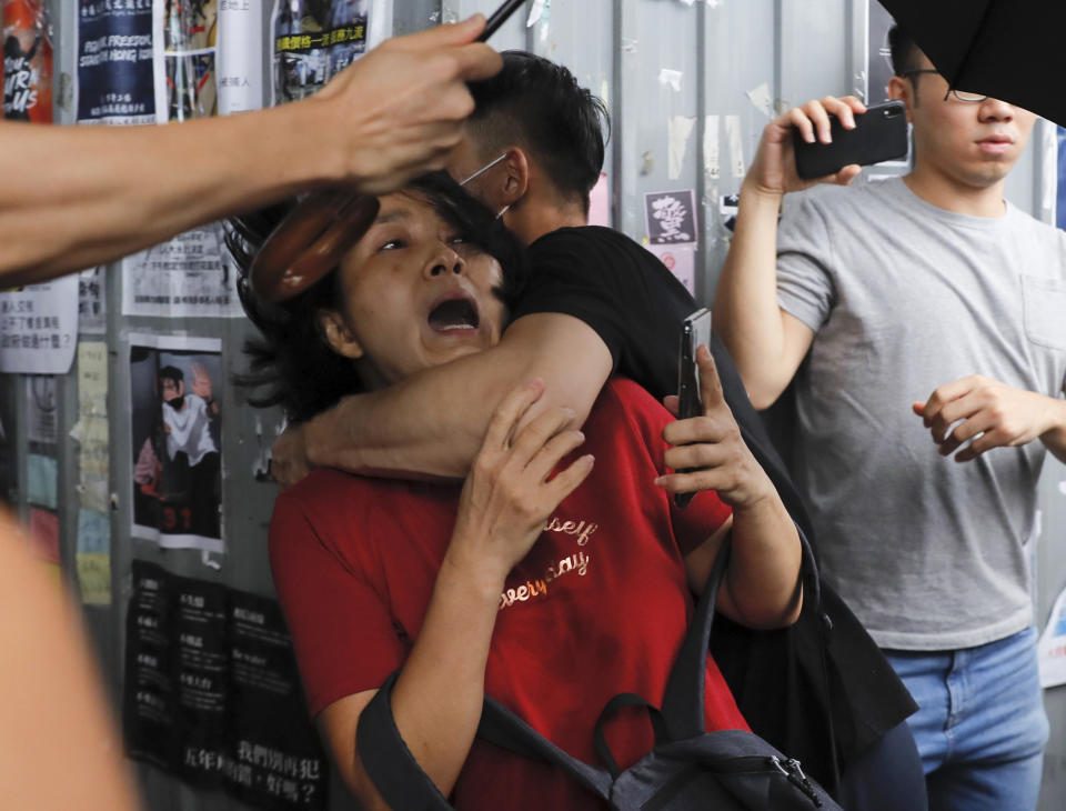 A Pro-China supporter, in red, struggles with an anti-government protester at the Kowloon Bay district in Hong Kong, Saturday, Sept. 14, 2019. The clashes came after several nights of peaceful rallies that featured mass singing at shopping malls by supporters of the months-long protests demanding democratic reforms. (AP Photo/Kin Cheung)