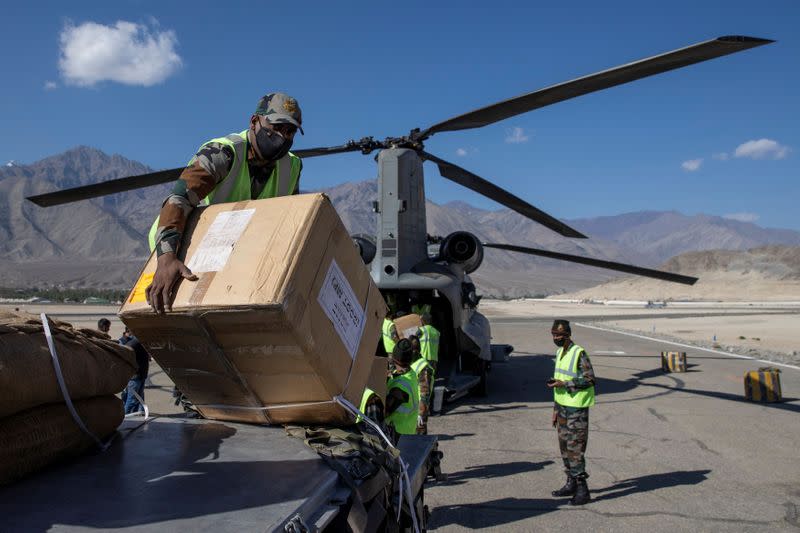 Soldiers load an Indian Air Force's Chinook helicopter with supplies at a forward airbase in Leh