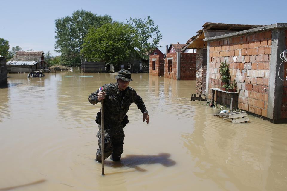 Serbian "Gendarmerie" police officer walks through a flooded street in Obrenovac