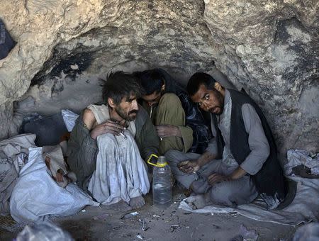 Afghan drug addicts smoke heroin inside a cave in Farah province February 4, 2015. REUTERS/Omar Sobhani