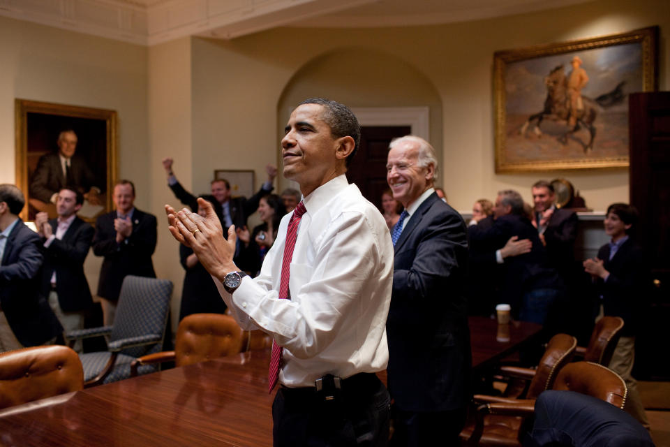 Former President Barack Obama, then Vice President Joe Biden and senior staff applaud in the Roosevelt Room of the White House, as the House passes the health care reform bill, March 21, 2010. - Credit: The White House