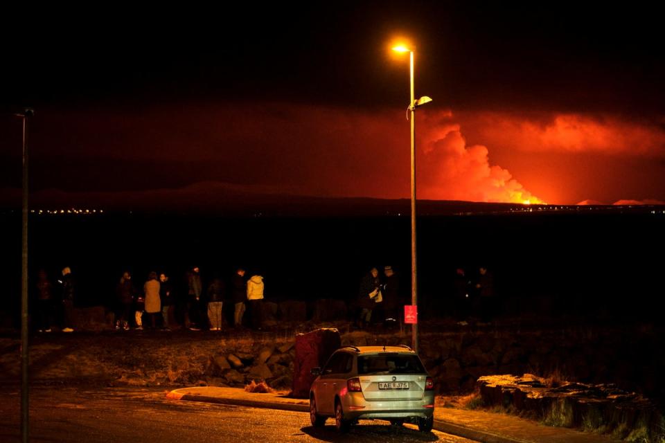 Thrill-seekers watch the gas plumes and lava from a distance in Iceland (EPA)