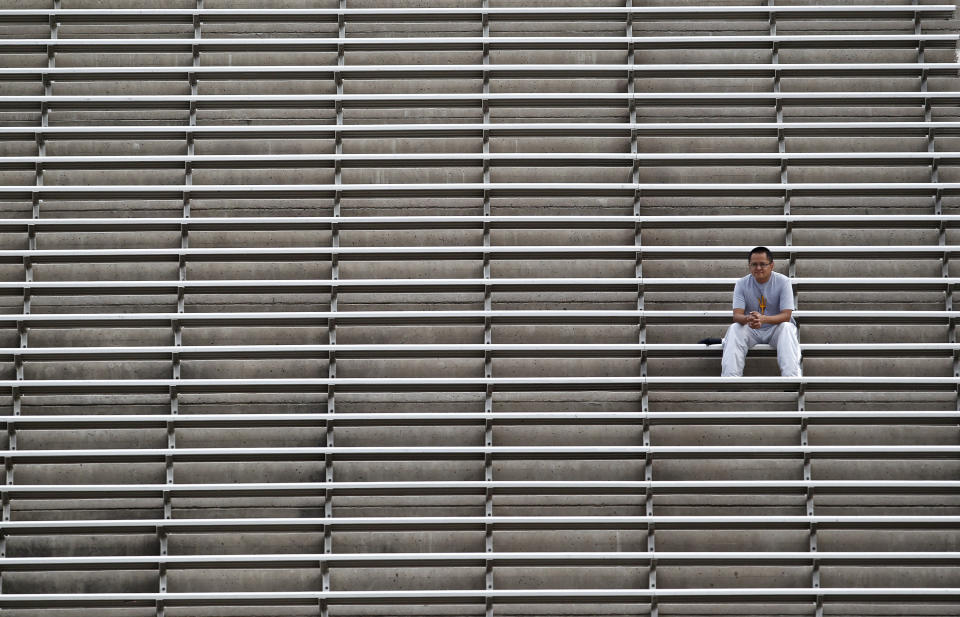 FILE - In this Nov. 17, 2012, file photo, an Arizona State fan is all alone in the upper deck during an NCAA college football game against Washington State, in Tempe, Ariz. As lock-downs are lifted, restrictions on social gatherings eased and life begins to resemble some sense, sports are finally starting to emerge from the coronavirus pandemic. Many college and pro sports teams already were dealing with declining ticket sales. The improved at-home experience, the emergence of wide-spread legalized betting and the changing social makeup of fan bases have been catalysts, while dynamic pricing, increases in parking and concession prices and a push toward luxury seating have exacerbated the problem.(AP Photo/Ross D. Franklin, File)