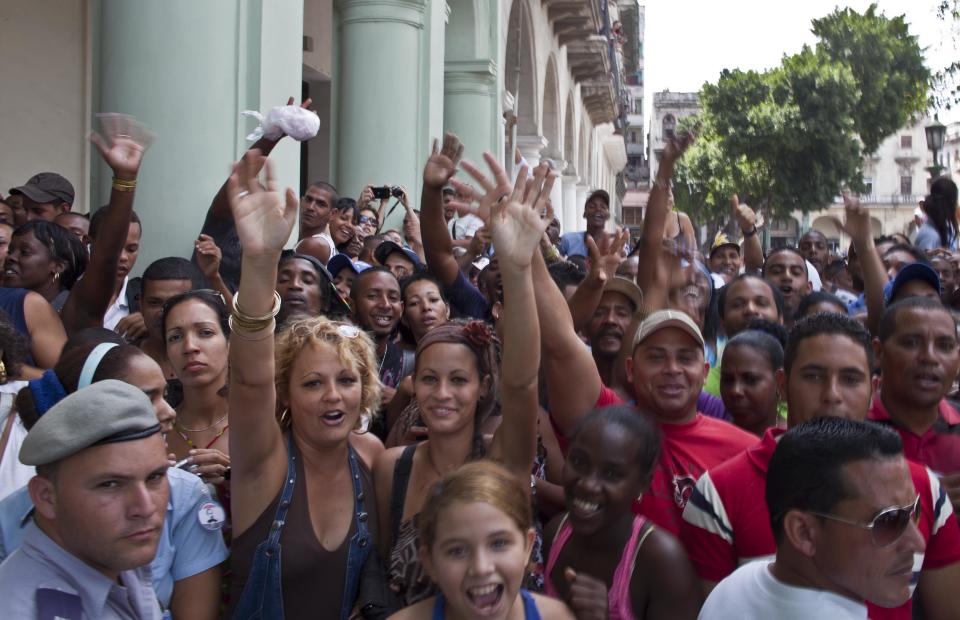 People react to the press as they wait outside the Saratoga hotel to see U.S. singer Beyonce in Old Havana, Cuba, Thursday, April 4, 2013. Beyonce is in Havana with her husband, rapper Jay-Z, on their fifth wedding anniversary. (AP Photo/Ramon Espinosa)