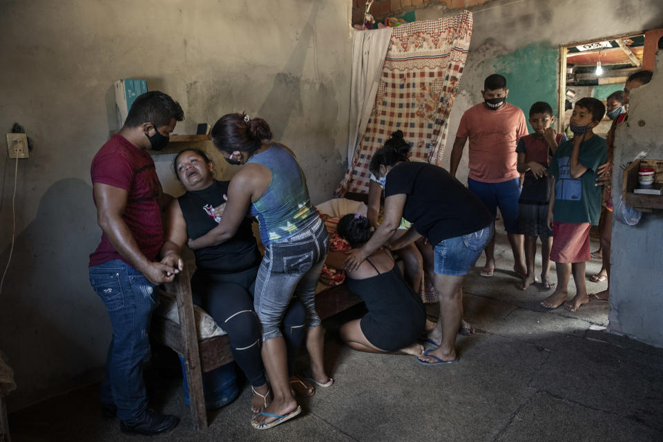 Familiares lloran a Gertrude Ferreira dos Santos, quien pasó toda su vida a orillas del Amazonas y murió en su casa durante la pandemia del coronavirus, en Manaos, Brasil, el 20 de mayo de 2020. (Tyler Hicks/The New York Times).