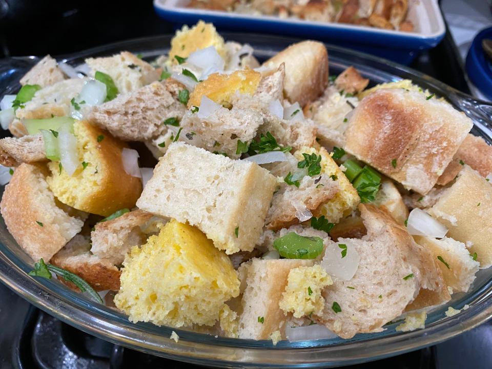 Mixing the ingredients for Ree Drummond's stuffing in metal bowl