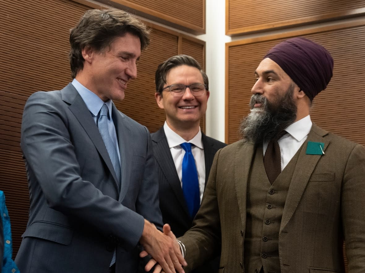 Prime Minister Justin Trudeau shakes hands with New Democratic Party Leader Jagmeet Singh as Conservative Leader Pierre Poilievre looks earlier this year. The Conservatives and the New Democrats were critical of the Trudeau government's budget this week.  (Adrian Wyld/The Canadian Press - image credit)