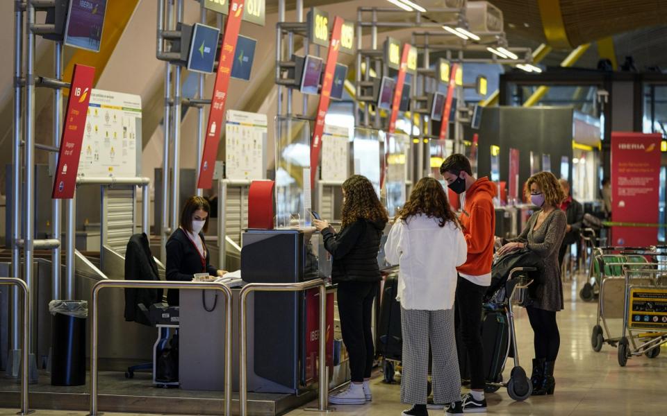 Passengers use a check-in counter in the departures hall at Madrid Barajas airport - Paul Hanna/Bloomberg