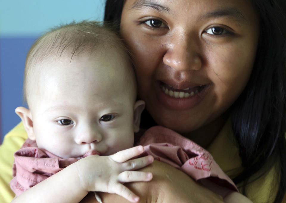 Thai surrogate mother Pattaramon Chanbua, a 21-year-old food vendor, poses with Gammy at nine months. Source: AAP