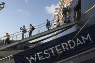 Passengers of the MS Westerdam, owned by Holland America Line disembark from the MS Westerdam, at the port of Sihanoukville, Cambodia, Saturday, Feb. 15, 2020. After being stranded at sea for two weeks because five ports refused to allow their cruise ship to dock, the passengers of the MS Westerdam were anything but sure their ordeal was finally over. (AP Photo/Heng Sinith)