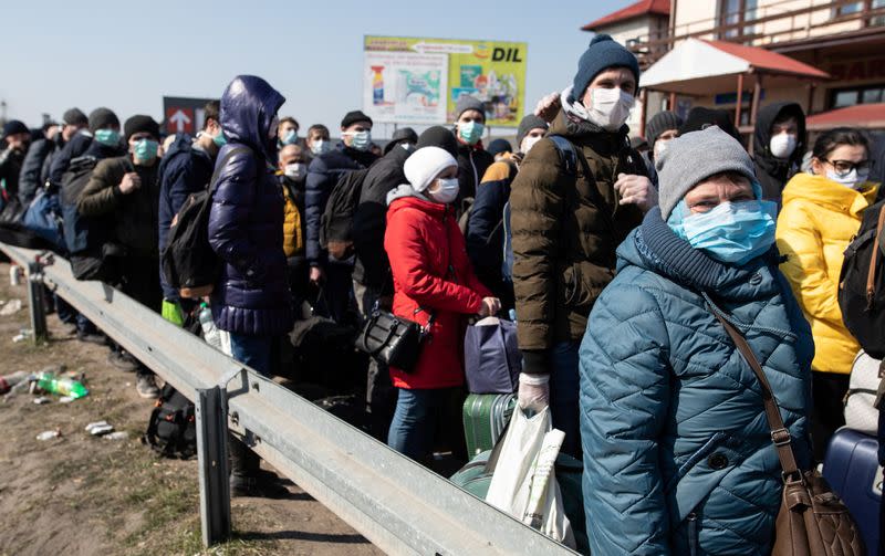 People queue to cross to Ukraine at the border crossing in Dorohusk