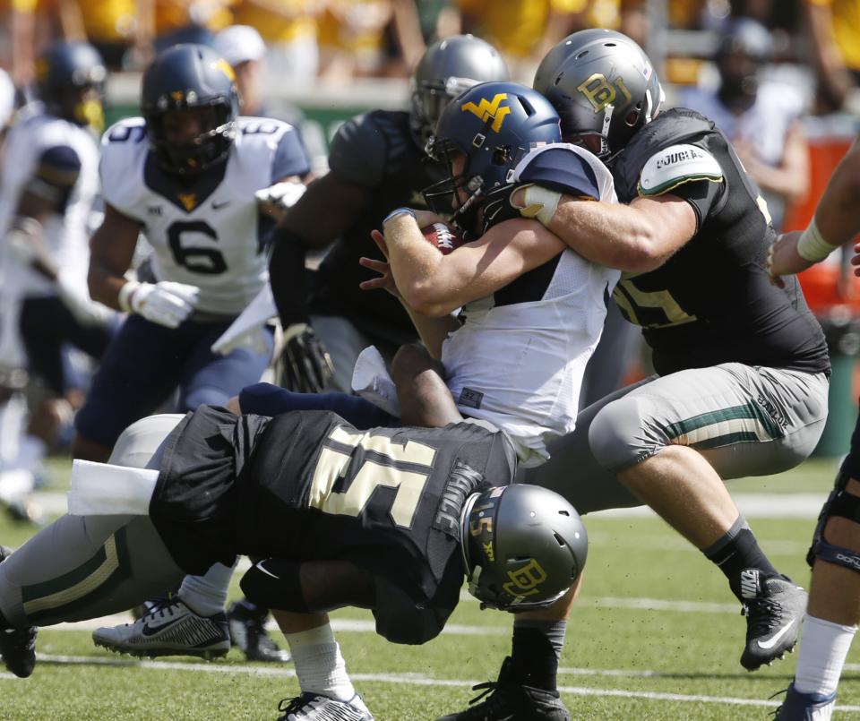 West Virginia quarterback Skyler Howard (3) is pulled down by Baylor defensive end Brian Nance (15), left and Beau Blackshear, right, in the second half of an NCAA college football game, Saturday, Oct 17, 2015, in Waco, Texas. (AP Photo/Rod Aydelotte)