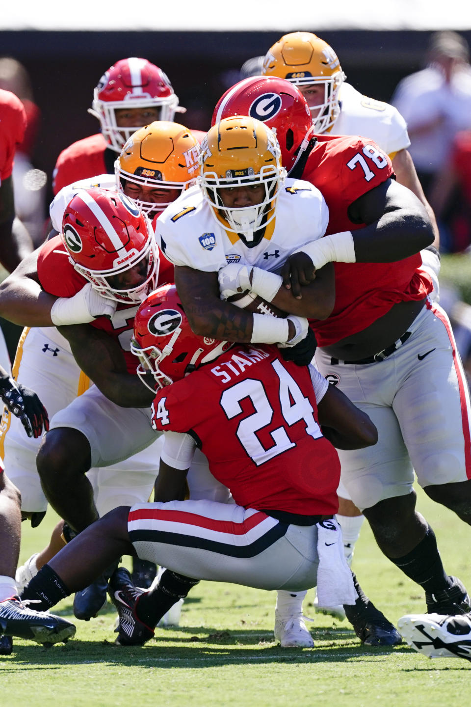 Kent State running back Marquez Cooper (1), center, is stopped by Georgia defenders Malaki Starks (24), Nazir Stackhouse (78), and Javon Bullard (22) in the first half of an NCAA college football game Saturday, Sept. 24, 2022, in Athens, Ga. (AP Photo/John Bazemore)