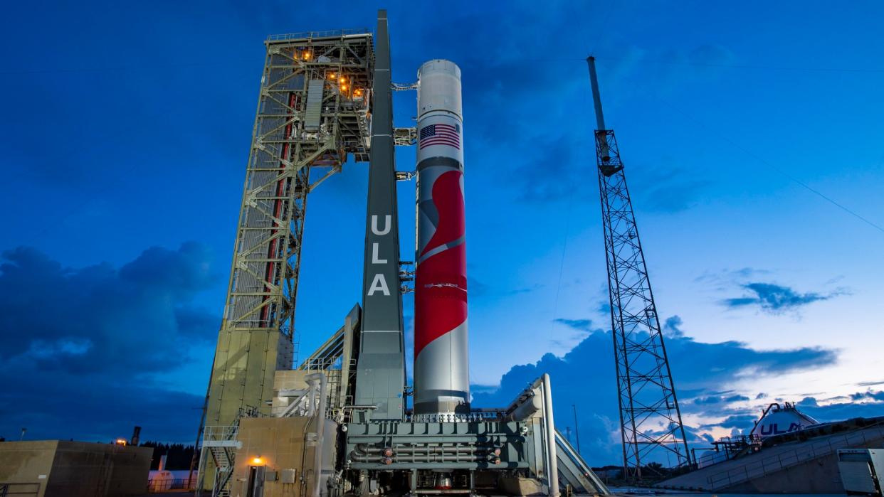  a red-and-white rocket on a launch pad at sunset 