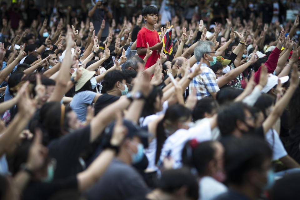 Pro-democracy protesters flash the three-finger protest salute during an anti-government rally at a major intersection in Bangkok, Thailand, Wednesday, Nov. 18, 2020. Police in Thailand's capital braced for possible trouble Wednesday, a day after a protest outside Parliament by pro-democracy demonstrators was marred by violence that left dozens of people injured. (AP Photo/Wason Wanichakorn)