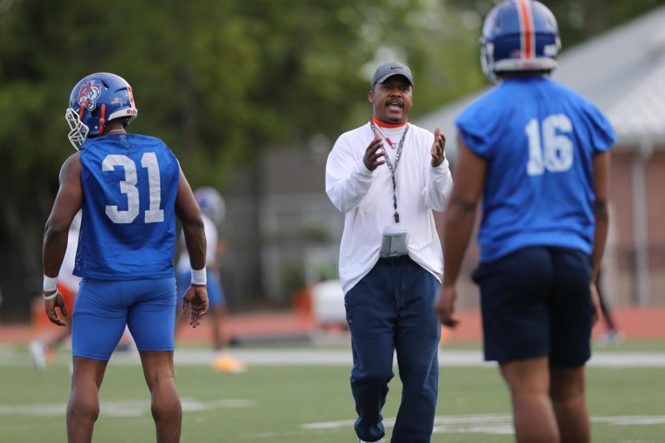 New head coach Aaron Kelton talks with line backer Daniel Whitehead as he leads his first practice at Savannah State University.