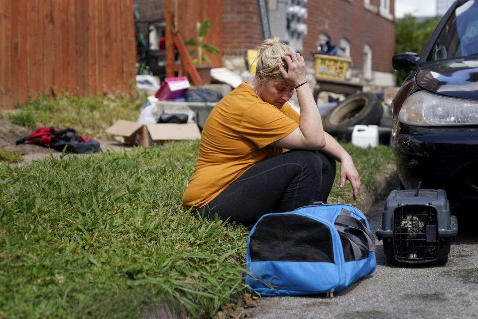 Kristen Bigogno sits on a curb with her belongings and her pets after being evicted from her home Friday, Sept. 17, 2021, in St. Louis. Bigogno is among thousands of Americans facing eviction now that the national moratorium has ended. (AP Photo/Jeff Roberson)