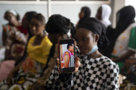 FILE - In this Sept. 23, 2021, file photo, Oumie Nyassi shows a video circulating on the internet and that has been confirmed as fake news of a woman claiming she was magnetized after receiving the COVID-19 vaccine, in a doctor's office at Serrekunda, Gambia hospital. Last spring, as false claims about vaccine safety threatened to undermine the world's response to COVID-19, researchers at Facebook wrote that they could reduce vaccine misinformation by tweaking how vaccine posts show up on users' newsfeeds, or by turning off comments entirely. Yet despite internal documents showing these changes worked, Facebook was slow to take action. (AP Photo/Leo Correa, File)