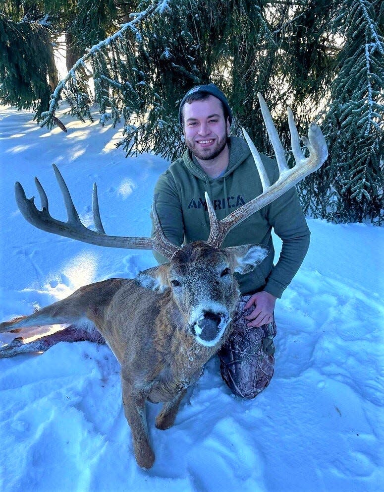 James White, 31, poses with a white-tail deer he brought down on the last day of the bow hunting season in February. With a rough green score of 174, it's the biggest deer White has bagged in his 23 years of hunting.