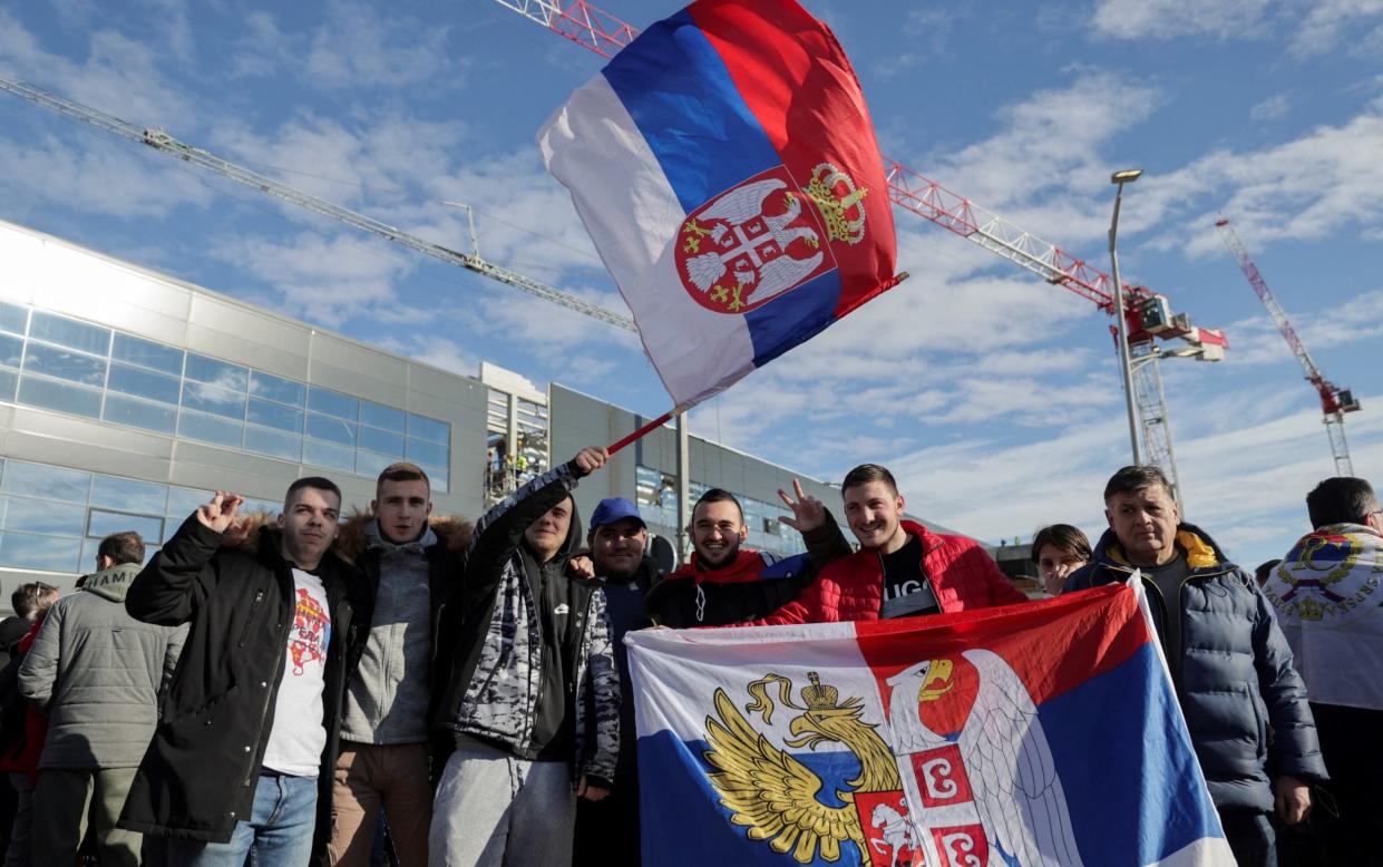 Fans of Serbian tennis player Novak Djokovic wave Serbian flags as they wait for his arrival at Nikola Tesla Airport - MARKO DJURICA /REUTERS