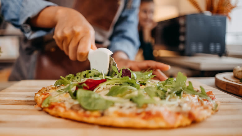 pizza slicer cutting pizza